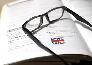 Un libro de aprendizaje de inglés con ejercicios y unas gafas encima