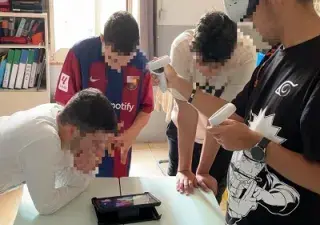 Varios alumnos probando uno de los proyectos presentados y con la cara pixelada por seguridad al ser menores (Fuente: Autismo España y Fundación Orange)