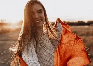 mujer con una puesta de sol al fondo