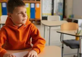 niño en un colegio sentado en el pupitre
