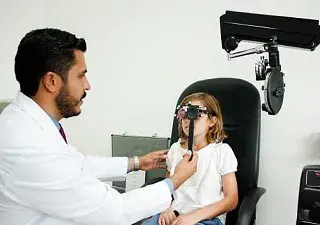 Doctor revisando a una niña los ojos