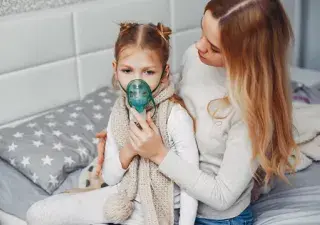 madre poninedo mascarilla de inhalacion a su hija