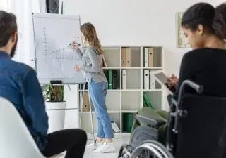 Mujer con discapacidad dísica atendiendo a una clase lectiva
