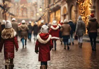 Una niña pasea por la calle de una ciudad en plena Navidad, junto a más gente (Fuente: 123RF/itchaznong)