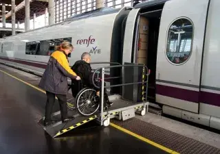 hombre en silla de ruedas subiendo al tren con la ayuda de una trabajadora de Renfe