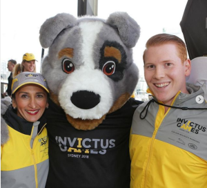 Voluntarios de la competición junto a la mascota de los mismos
